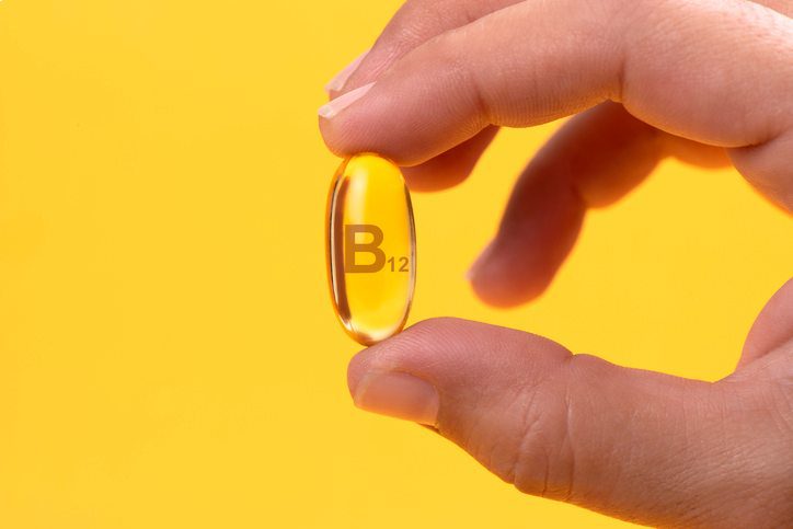 Hand Holding Vitamin B12 capsule Hand Holding Vitamin B12 capsule